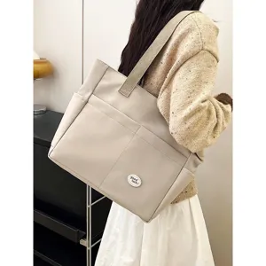 Large capacity canvas tote bag for women, casual commute shoulder bag with pockets.