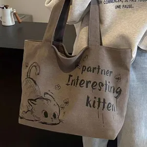 Detailed shot of casual canvas tote bag with cute cat print and stylish typography text.