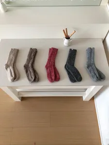 Detailaufnahme von gemütlichen, dicken Wollstrick-Socken in verschiedenen Farben ordentlich präsentiert.