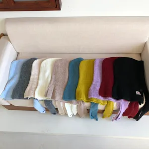 Close-up details of various colors knitted balaclava hoods, soft warm winter wool hats.