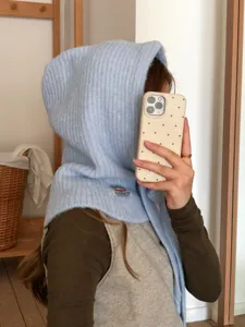Close-up detail of cozy light blue knit balaclava hood scarf, soft ribbed texture.