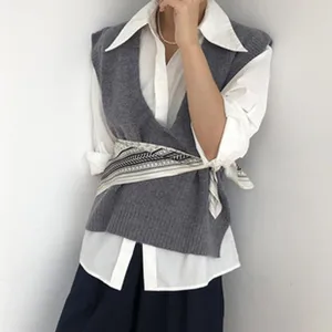 Detail view of a luxury silk square scarf worn as a chic waist accessory for women.