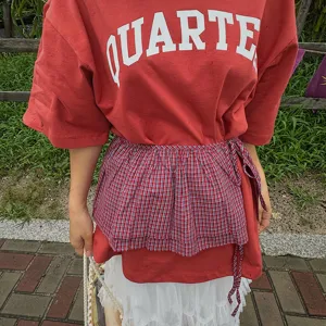 Koreaanse mode gelaagde nep wikkelrok gecombineerd met rood t-shirt voor trendy dagelijkse outfit.