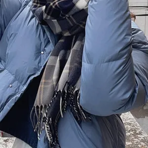 Detailansicht des klassischen blau karierten Winterschals mit weichem Stoff und Fransen.