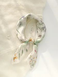 Vue détaillée d'un carré de soie de mûrier pure avec motif floral et insectes élégants.