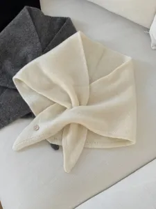 Detailansicht des weichen Wollminischals mit Knopfverschluss, kuscheliges Winteraccessoire.
