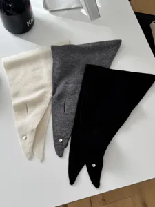 Detailansicht weicher Wolltücher in Wollweiß, Grau und Schwarz mit praktischem Schlitz.