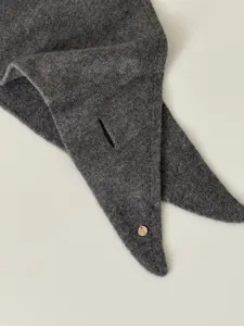 Detailansicht des dunkelgrauen Wollschals mit Schlitzdesign und weicher, warmer Textur.