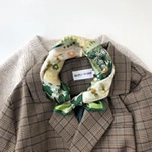 Detailansicht eines vintage Seidenschals mit botanischem Muster, kombiniert mit Karoblazer.