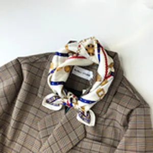 Vista detallada de un pañuelo de seda cuadrado con estampado retro de carroza y blazer.