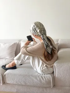 Detailaufnahme eines schwarz-weißen Paisley-Dreischeitels als Kopftuch oder Accessoire.