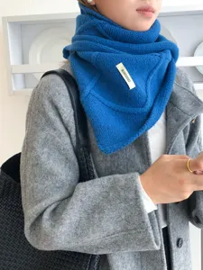 Primer plano de la bufanda de punto azul mostrando la textura del diseño de botones para invierno.