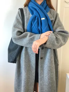 Bufanda de invierno de punto azul vista detallada, diseño cruzado cómodo para días fríos.