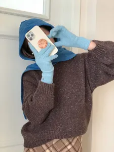 Cozy knit balaclava hat and scarf integrated set paired with sweater and gloves detail shot.
