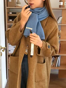 Primer plano detallado de una suave bufanda de lana azul, llevada con un estilo elegante.