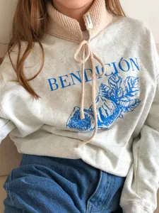 Detailansicht des winterlichen Woll-Halswärmers und des stylischen bedruckten Sweatshirts.