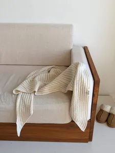Vue détaillée d'un châle écharpe triangulaire en laine tricotée ajourée beige pour femme.
