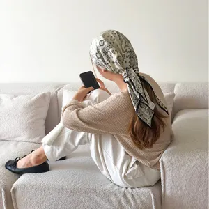 Schwarz-weisses Paisleymuster Dreieckstuch, stilvolles Kopftuch und modischer Haarschmuck.