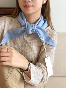 Vista detallada de un pañuelo triangular de lana azul claro suave para un estilo cálido y elegante.