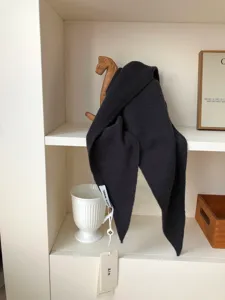 Vista detallada del pañuelo triangular de lana pura gris oscuro con textura suave y estilo minimalista.