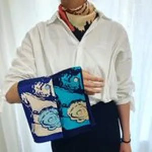 Detalle de pañuelo cuadrado de seda con estampado ecuestre clásico y elegante tono azul.