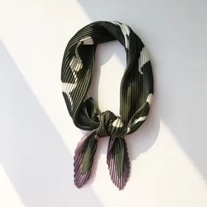 Detail shot of the pleated green small square scarf showing fine texture and artistic fold.