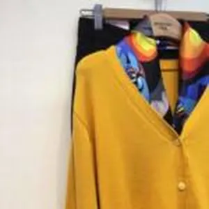 Einfarbig gelbe Strickjacke mit bunten Seidentuch kombiniert, hängende Damenpräsentation.