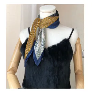 Detailed view of a vintage pleated small square scarf with yellow and blue plaid patterns.
