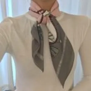 Close-up detail of the elegant printed silk scarf tied neatly around the neck for styling.