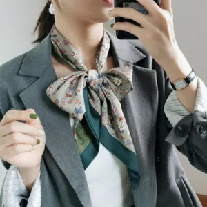 Detailansicht des eleganten Damenschals mit Blumenmuster und kontrastierendem gruenem Rand.