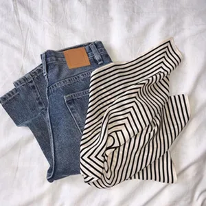 Classic French style denim pants and striped fabric flat lay photography, minimalist casual clothing display.