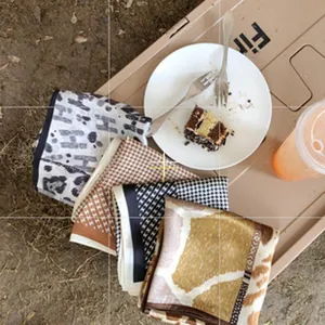 Detailed view of luxury silk square scarf featuring chic geometric and animal prints.