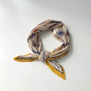 Close-up detail of pleated vintage floral small square scarf with elegant yellow border design.