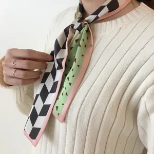 Gros plan détaillé d'un foulard en soie étroit à motifs géométriques noué élégamment au cou.