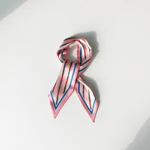 Chic foulard en soie rose avec motif de rayures et boucles, accessoire polyvalent pour sac.