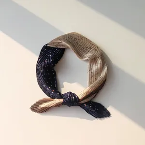 Close-up detail of the pleated small square scarf with elegant two-tone retro pattern.