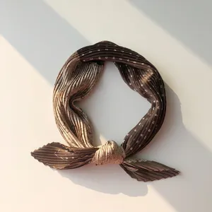 Detailed view of brown pleated square scarf, chic retro neck accessory for stylish wear.