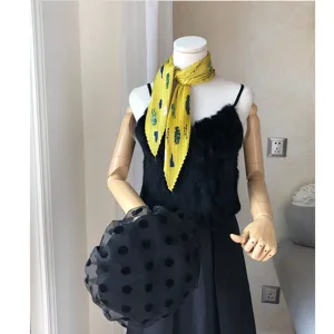 Detail view of the yellow pleated small square scarf with retro print, elegant neckerchief.