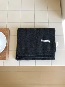 Detalle de bufanda de lana gruesa gris oscuro, accesorio de invierno cálido y suave.