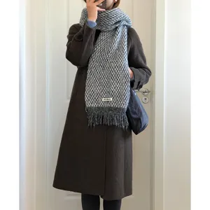 Cozy grey patterned winter scarf detail, soft fringe design, elegant cold weather accessory.