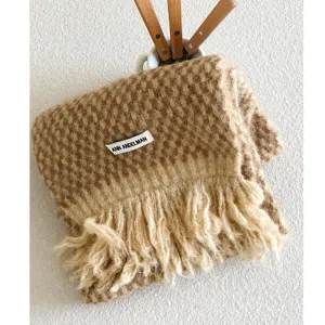 Knotted wool-blend scarf detail, soft tassel texture, cozy winter warm fashion accessory.
