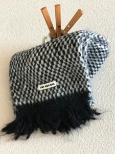 Detail view of the soft black and white patterned winter fringe scarf with cozy texture.
