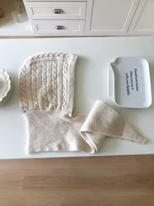 Cozy beige knit balaclava scarf combo with cable pattern and warm wool fabric in detail.
