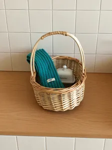 Primer plano detallado del pañuelo bufanda de punto verde liso expuesto en la cesta.