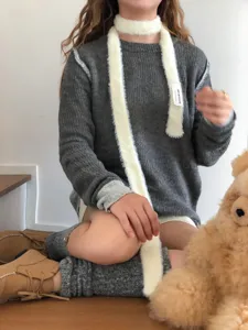 Detailed view of y2k style fluffy long narrow scarf worn by model indoors, fashion accessory.