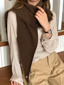 Close-up detail of the soft brown wool-blend triangular scarf worn with knitwear.