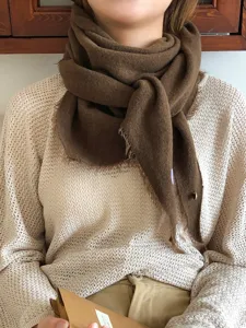 Close-up detail of the cozy wool-blend triangular scarf showing soft texture and warm style.