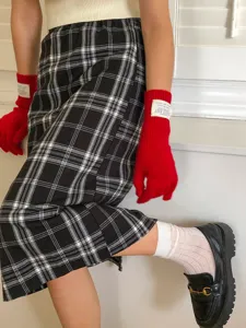 Gros plan de gants tactiles en tricot rouge vif avec étiquette au poignet, accessoire d'hiver.