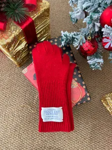 Gants d'hiver en tricot rouge gros plan détail avec fond de boîte cadeau de Noël festive.