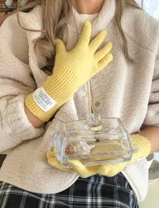 Gros plan sur des gants d'hiver en tricot jaune chaud avec une texture douce et une belle étiquette.